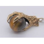 A 9ct gold and tiger's eye set claw pendant, 5.8g, 24mm