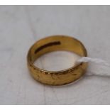 A 22ct gold wedding band having engraved decoration 4.4g, size J
