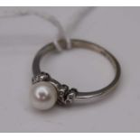 A contemporary white metal, cultured pearl and diamond point set dress ring, 2.4g, size L/M