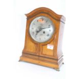 An early 20th century oak cased eight-day mantel clock, the silvered dial showing Roman numerals and