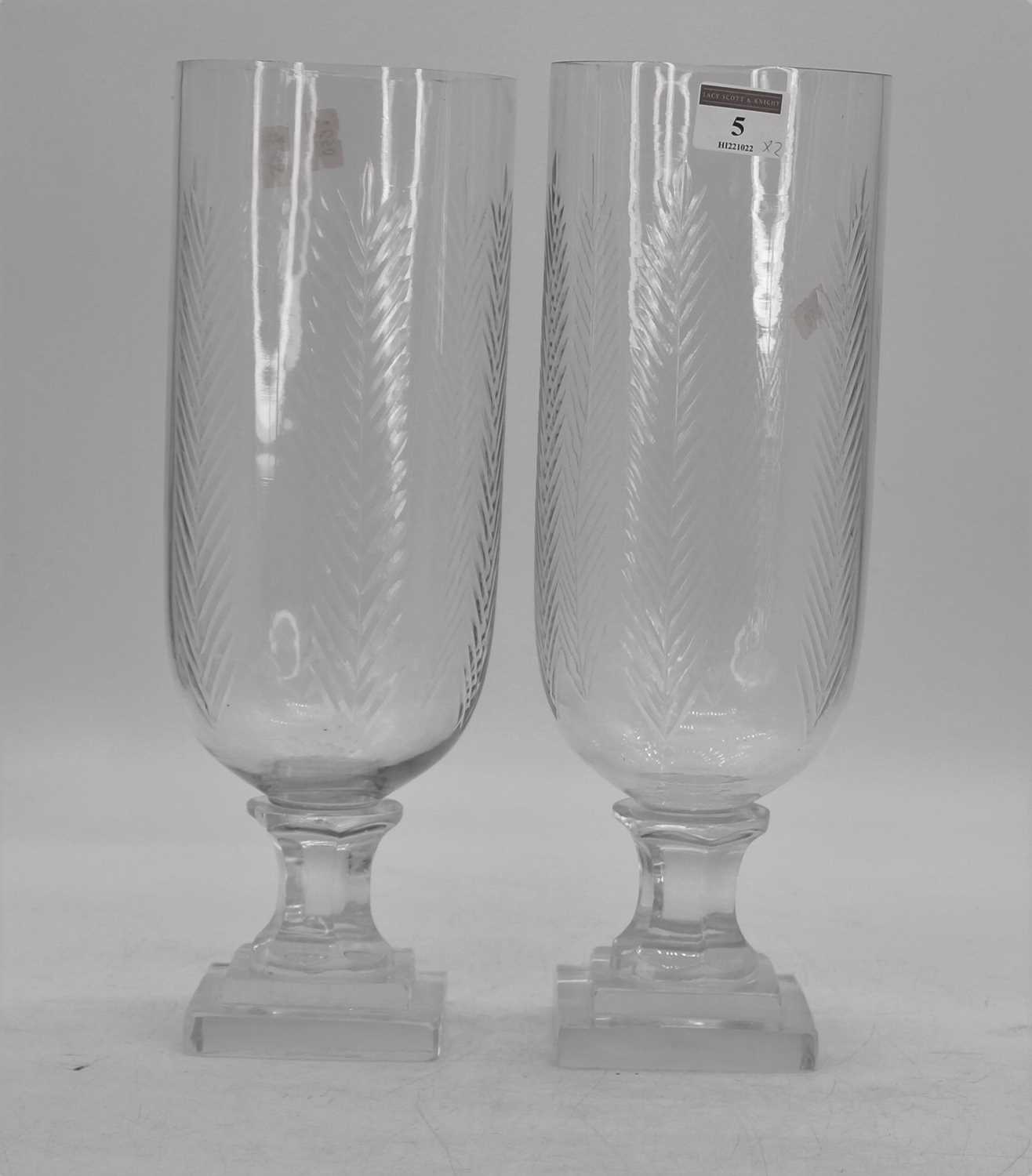 A pair of cut glass storm lamps, each upon a faceted stem and stepped plinth, h.34cmNo damage.