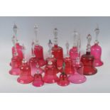 A collection of fifteen 19th century Nailsea type cranberry glass bells, to include a silver handled