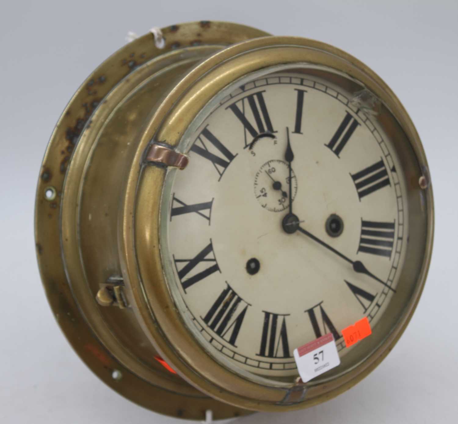 A brass ship's clock, the dial showing Roman numerals and subsidiary seconds dial, having eight-