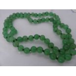 A beaded and knotted green glass necklace, 68cm