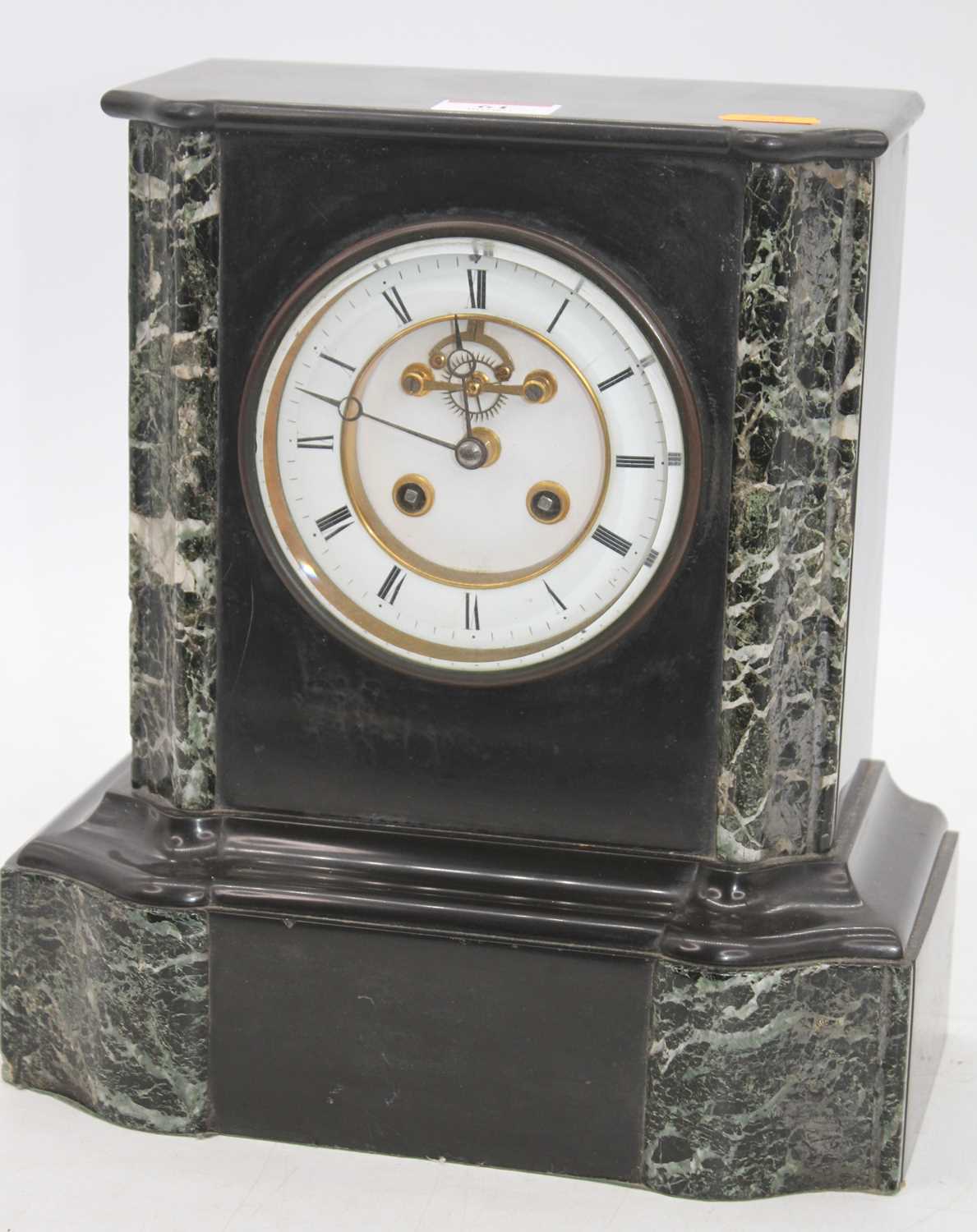 A Victorian black slate mantel clock, the enamelled chapter ring showing Roman numerals, the eight-