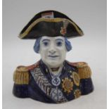 A faience polychrome decorated jug, in the form of Lord Nelson, inscribed PMO to the underside, h.