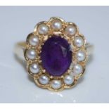 A 14ct yellow gold, amethyst and seed pearl oval cluster ring, featuring an oval faceted amethyst