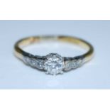 A yellow and white metal diamond single stone ring, comprising a centre round brilliant cut