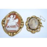 Two brooches, being a yellow metal oval carved shell cameo brooch depicting a cherub riding a horse,