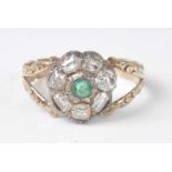 A yellow and white metal, emerald and diamond circular cluster ring, comprising a centre round