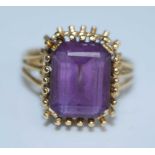 A yellow metal amethyst dress ring, featuring a rectangular cut amethyst in a fringe setting with