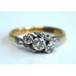 A yellow and white metal diamond three stone crossover ring, the single cut diamonds in illusion