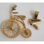 A yellow metal pendant fashioned as a penny farthing bicycle, stamped 18k and tests as 18ct gold,
