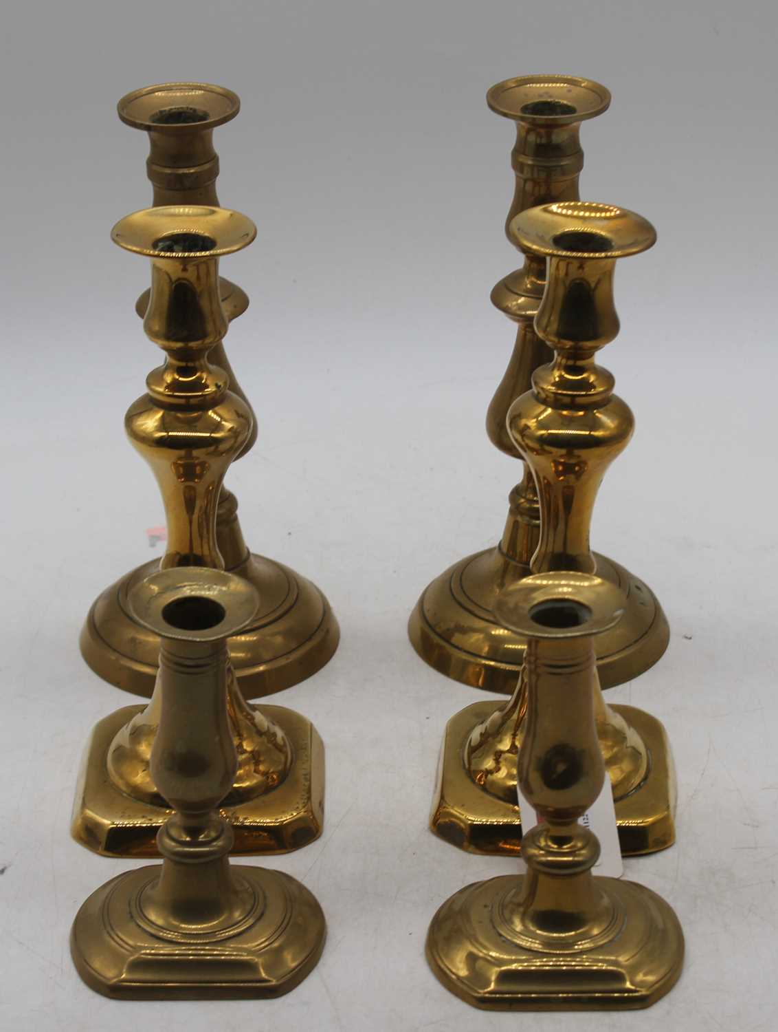 A pair of mid 19th century turned brass candlesticks with ejectors, height 24cm, together with two