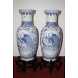 A pair of Chinese blue and white porcelain floor vases, each decorated with birds amongst flowers,