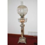 A Victorian style oil lamp, having globular shade above a clear glass font, on a faux marble