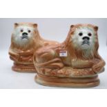 A pair of Sadler hollow moulded figures, each in the form of a recumbent lion with glass eyes having