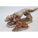 A Capo di Monte model of a spaniel, h.12cm; together with one other similar, h.11cm