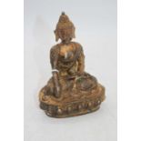 A reproduction gilt metal figure of a deity, in seated pose, h.15cm