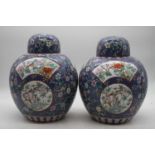 A pair of Chinese export jars and covers, each of globular form, on a blue ground with opposing