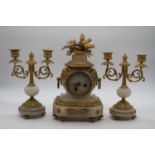 A late 19th century French gilt metal and onyx clock garniture, the central clock surmounted by