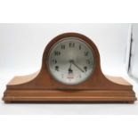 A 1920s walnut cased mantel clock having a silvered dial with Arabic numerals and chiming