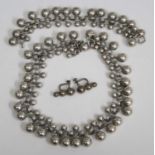 A contemporary white metal beaded necklace with matching bracelet and ear clips