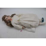 A vintage bisque headed doll, having opposable bisque hands and legs, signed with monogram SG to the