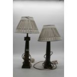 A pair of bronze alloy table lamps, each having a Doric capital on tapered column and stepped square