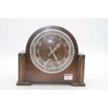 A 1950s Smiths oak cased mantel clock having plastic chapter ring with Arabic numerals and eight day
