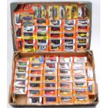 Two trays containing a large collection of various Matchbox Mattel wheels, boxed and carded