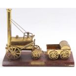 A brass static display model on wooden base depicting the Stephenson's Rocket, base length 33cm, max