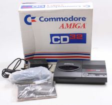 A Commodore Amiga CD32 console, housed in the original card box, comprising of console, power