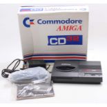 A Commodore Amiga CD32 console, housed in the original card box, comprising of console, power