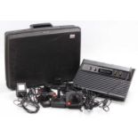 A plastic case containing a loose Atari 2600 console, and various power leads, hand controllers,