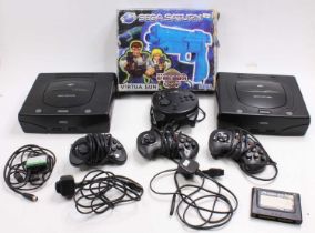 A collection of Sega Saturn loosed consoles, control pads, memory cards, power leads and