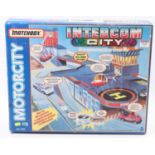 A Matchbox Motorcity No. MC-563 Intercom City play set containing various buildings and scenery,