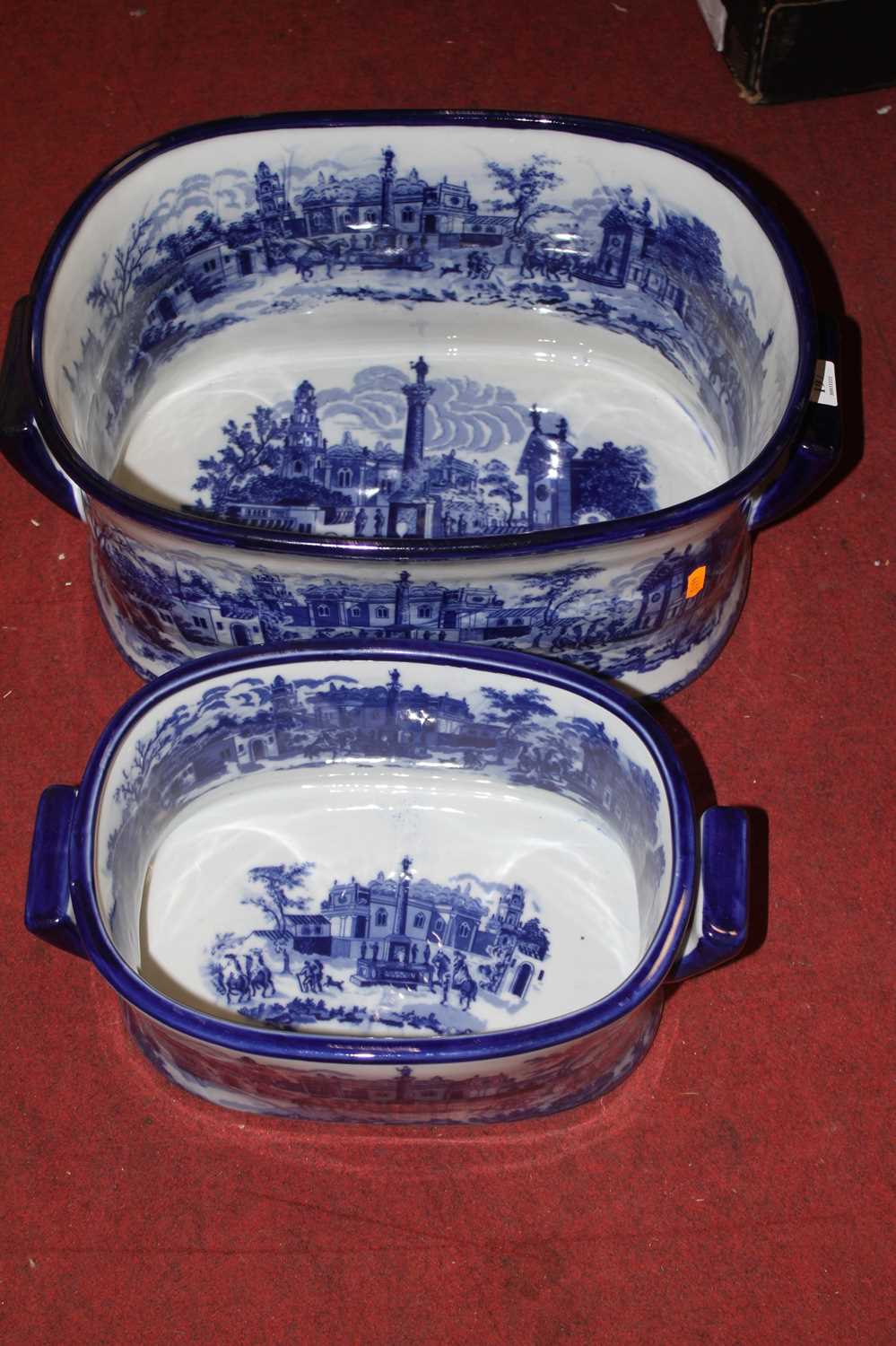 Two graduated blue & white transfer decorated pottery foot baths, largest width 48cm