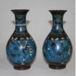 A pair of Chinese cloisonne enamel vases, each decorated with birds amongst flowers, h.18cmOne has a