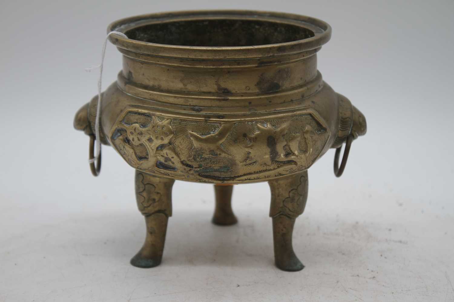 A Chinese brass tripod censer, flanked by zoomorphic handles, zhuanshu seal mark to the underside,