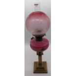 A Victorian brass oil lamp, the acid etched shade above a pink glass font and reeded stem, height