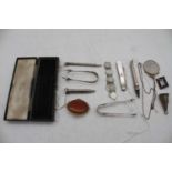 A small collection of miscellaneous items to include a pair of silver sugar tongs, silver propelling