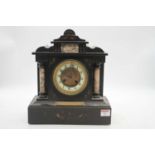 A Victorian black slate mantel clock of architectural form, the enamel chapter ring showing Arabic