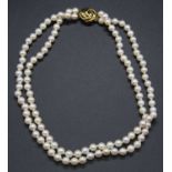 A cultured pearl double string knotted choker, on 9ct gold clasp, 38cm