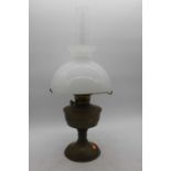 A brass oil lamp, having milk glass shade, height 61cm