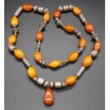 A faux amber and white metal beaded and knotted necklace, 80cm