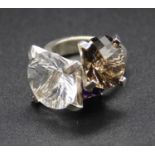 A contemporary white metal and semi-precious three stone set dress ring, to include amethyst and