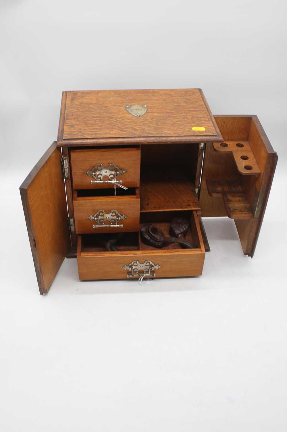 An early 20th century oak smoker's cabinet, the doors opening to reveal a pipe rack and drawers, - Image 2 of 3