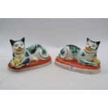 A pair of Staffordshire pottery models of cats, h.14cmOne is cracked underneath and chipped to the