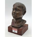 A mid-20th century bronze bust of a boy, naturalistically modelled, with indistinct etched signature